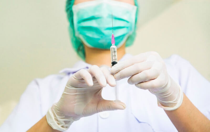 a nurse preparing anesthesia injection